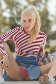Blonde cutie with foxy body teases with her pink and white panty as she walks around a campus wearing her red and white stripe shirt, blue skirt and white shoes.