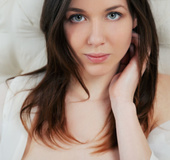 Tender gal in a sheer white top presents her parts in the bedroom.