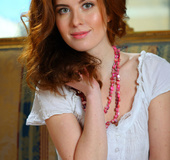 Welcoming girlie in a white dress flashes her red pubes on the sofa.