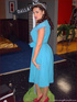 Wild ponytailed brunette in a blue dress rocking at the pole undressing