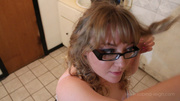 Beautiful blonde with glasses takes off her curlers before combing her blonde hair.