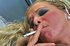Slutty blonde in a fur coat likes to smoke so much