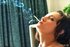 Cute brunette with glasses smokes in her bedroom with pleasure