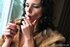 Elegant brunette in a fur coat loves to smoke so much