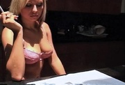 Blonde reads a magazine and smokes in the kitchen