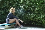 Lovely blonde darling loves to smoke by her pool