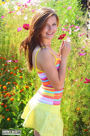 Lovely hottie shows her juicy tits as she pulls down her colorful shirt before she takes it off with her yellow skirt and green panty then shows her sweet pussy as she opens her legs wide in a flower garder. - Picture 7