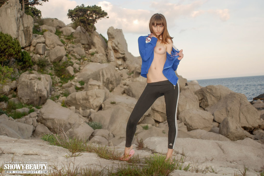 Hot brunette takes off her blue shirt then teases with her small tits as she pose topless wearing her brown leggings then takes it off and allures with her erotic pussy in different poses on big rocks by the beach. - XXXonXXX - Pic 19