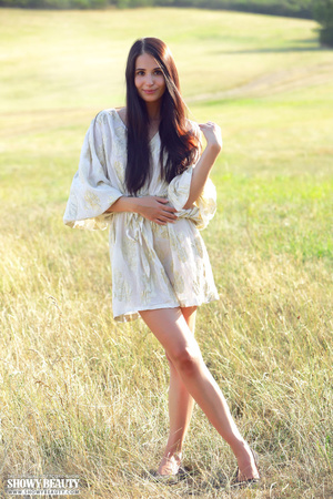 Pretty young babe lifts up her skirt and reveals her lusty pussy before she takes off her white robe and seduces with her small tits and skinny body as she pose naked on a grassy field. - XXXonXXX - Pic 1