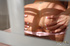 Indulging blonde teases on a white bed and sucks a blue and clear glass