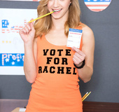 Marvelous harlot in an orange shirt and jeans jumps on a pole at the table.