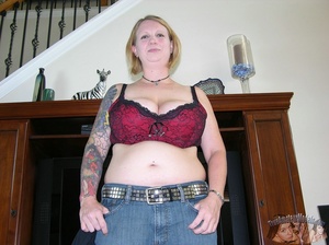 Chubby babe strips off her black shirt and black and maroon bra then releases her monster juggs before she peels down her jeans and black and maroon panty and expose her indulging pussy in different poses on a gray couch and brown bed. - Picture 3