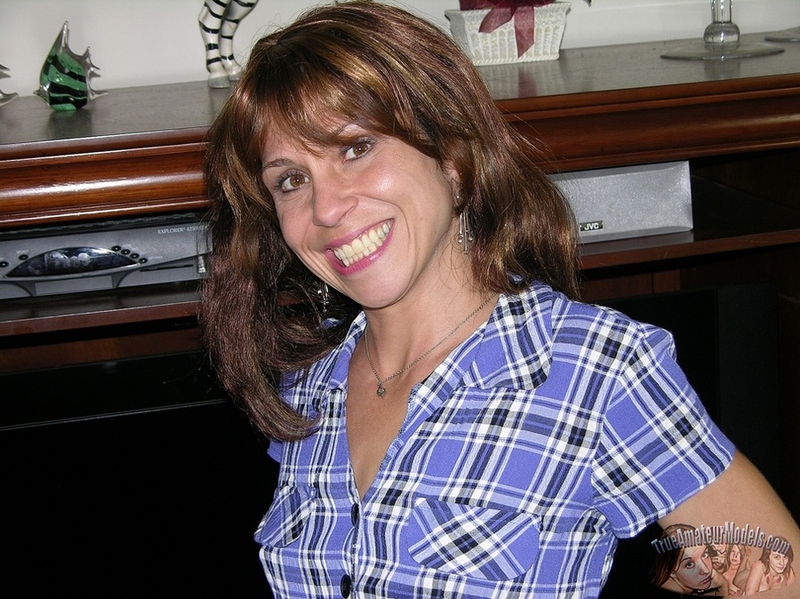 Hot MILF displays her sexy body on a gray couch before she pulls down her jeans and reveals her ravishing pussy then peels off her blue, black and white checkered shirt and shows her small boobs as she pose naked in different positions on a brown bed and wooden drawer. - XXXonXXX - Pic 2