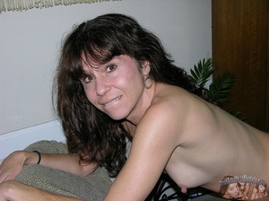 Mature hottie peels off her pink shirt and expose her small boobs and skinny body before she peels down her blue jogging pants and reveals her nasty crack in different poses on gray and brown couches and on a brown bed. - XXXonXXX - Pic 11