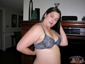 Chubby chick peels off her multi-colored shirt and gray bra then bares her huge boobs before she strips down her green shorts and pink and white panty then reveals her juicy pussy in different positions on a gray couch and a brown bed. - Picture 2