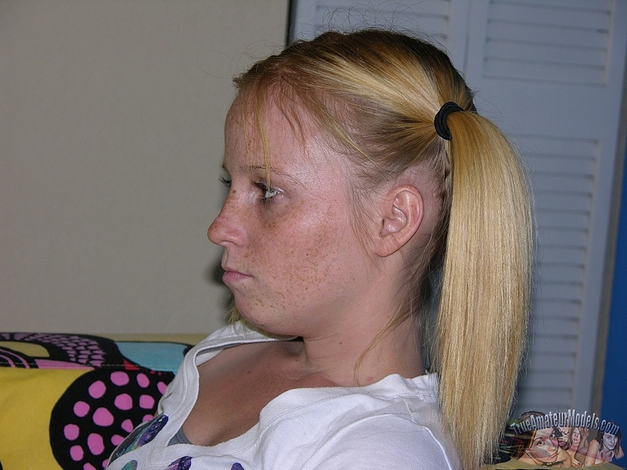 Teen blonde in pigtails sits on a multi-colored couch then takes off her white with vari-colored hearts shirt and gray bra and shows her tiny boobs before she peels down her jeans and reveals her lusty crack on a black and white bed. - XXXonXXX - Pic 2