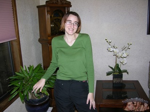 Nerdy chick with glasses slowly peels off her green shirt, black pants, bra and camouflage shorts then displays her skinny body with tiny tits and hairy pussy on a gray couch, brown bed and white tub. - XXXonXXX - Pic 1