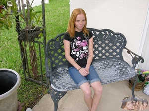 Freckled hottie sits on gray bench outdoor then goes inside and takes off her black shirt and shows her tiny tits before she peels down her jeans shorts and expose her sweet pussy on a gray couch and brown bed. - XXXonXXX - Pic 1