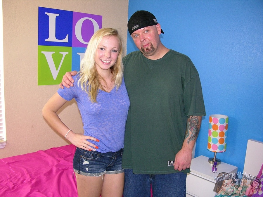 Stunning blonde with smoking hot body wearing blue shirt and jeans shorts grabs her boyfriend's dick and pumps it hard til it blows on her hot boobs on a pink bed. - XXXonXXX - Pic 1