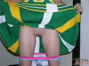 Teen cheerleader in pigtails peels down her pink and blue panty and expose her sweet pussy in different poses on a green seat wearing her green and yellow uniform before she takes it off and lays naked on a violet and white bed. - XXXonXXX - Pic 7