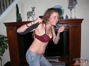 Curly redhead takes off her pink shirt then displays her banging body before she peels off her red and black bra and reveals her juicy tits then strips down her jeans and black panty and seduces with her alluring pussy in different positions on a gray couch, brown chair and bed. - XXXonXXX - Pic 3
