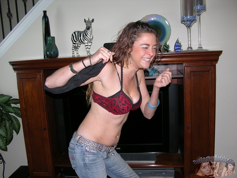 Curly redhead takes off her pink shirt then displays her banging body before she peels off her red and black bra and reveals her juicy tits then strips down her jeans and black panty and seduces with her alluring pussy in different positions on a gray couch, brown chair and bed. - XXXonXXX - Pic 3