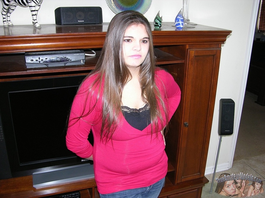 Pretty hottie sits on a gray couch and displays her chubby body then takes off her red jacket and black shirt and reveals her humongous boobs before she takes down her jeans and shows her huge booty then peels down her black thong and expose her ravishing pussy. - XXXonXXX - Pic 2