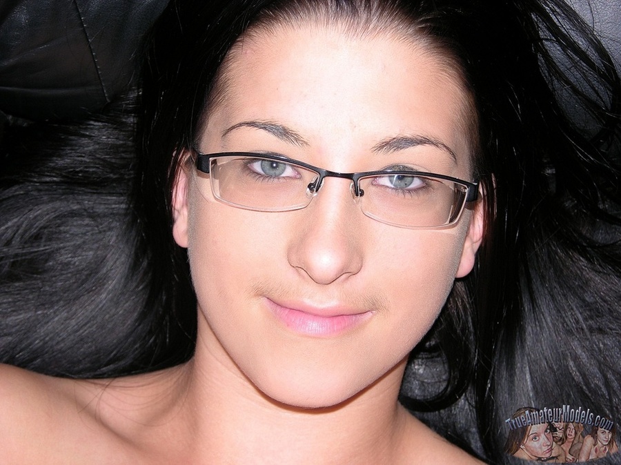 Pretty chick with glasses pose her banging body then strips down her gray pants and thong then reveals her luscious twat on a black couch before she takes off her gray shirt and expose juicy boobs as she sits naked on a black chair wearing her pink and black socks. - XXXonXXX - Pic 12