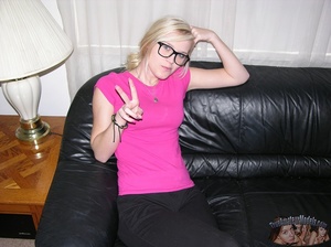 Pretty blonde with glasses takes off her pink shirt and black and blue bra then seduces with her small tits and slim body as she lays topless on a black couch before she peels down her black pants and expose her lusty crack as she opens her legs wide on a blue and white bed. - XXXonXXX - Pic 1