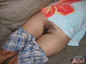 Hot chick strips down her gray shorts and expose her hairy pussy then takes off her blue and red floral dress and show she lusty boobs as she lays down naked on a gray couch. - XXXonXXX - Pic 6