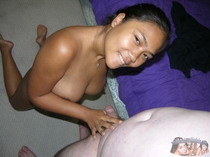 Thai chick teases a fat bald dude with her big boobs and hot body as she pose naked on a purple bed before she spreads her legs wide and lets him lick her pussy then holds his dick tight and jacks it hard. - Picture 2