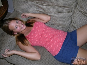 Beautiful young blonde peels off her pink shirt and blue shorts and displays her alluring body and hot boobs exposed as she lays down topless on a gray couch before she peels down her purple panty and teases with her lusty pussy on a brown stairway and white bed. - Picture 5