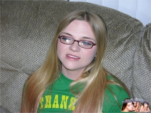 Teen blonde with glasses slowly strips off her green shirt, jeans skirt and black panty then reveals her sweet body with alluring tits and pussy on a gray couch before she gets on her knees and wanks a hard dick. - Picture 1