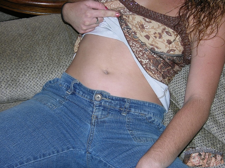 Curly brunette displays her stunning body on a gray couch before she takes off her brown blouse and bares her indulging tits then peels down her jeans and blue panty and reveals her indulging twat in different poses on a brown bed. - XXXonXXX - Pic 3