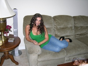 Smoking hot chick with curly brown hair pose on a gray couch before she peels off her green shirt and jeans then seduces with her banging body in black underwear before she takes them off and reveals her luscious boobs and stimulating pussy on a brown stairway and gray bed. - Picture 2
