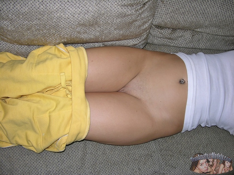 Pretty young hottie seduces with her hot body before she peels off her yellow pants and teases with her alluring twat then strips off her white shirt and bares her sweet tits in different poses on a gray couch, brown stairway and in a kitchen. - XXXonXXX - Pic 6