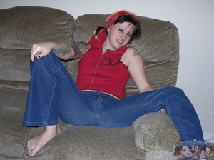 Tattooed and pierced hottie peels down her jeans and shows her sweet crack on a gray couch then takes off her red shirt and bares her small tits in different poses on a gray couch. - XXXonXXX - Pic 3