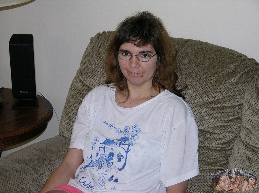 Nerdy chick with glasses peels down her pink shorts and blue panty then reveals her erotic pussy on a gray couch before she takes off her white shirt and expose her big tits as she lays naked on a gray bed. - XXXonXXX - Pic 3