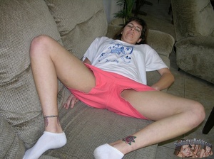 Nerdy chick with glasses peels down her pink shorts and blue panty then reveals her erotic pussy on a gray couch before she takes off her white shirt and expose her big tits as she lays naked on a gray bed. - XXXonXXX - Pic 4