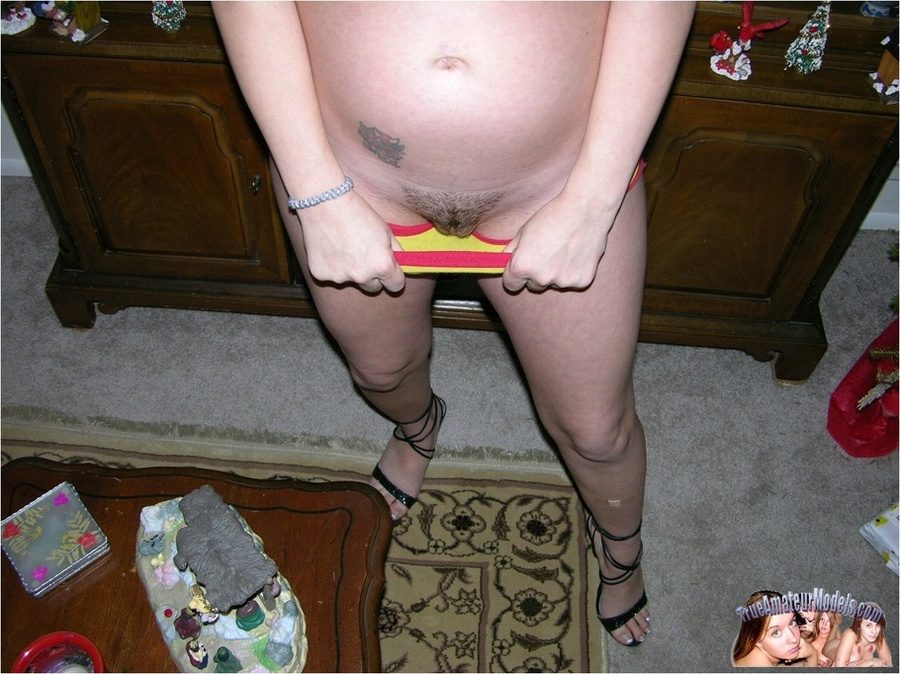 Pregnant babe takes off her green shirt and bares her luscious round boobs and big tummy before she peels down her white shorts and yellow panty and expose her juicy pussy on a maroon bed. - XXXonXXX - Pic 7