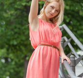 Lovely blonde in pretty peach dress pose outdoor before she goes in her