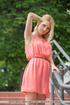 Lovely blonde in pretty peach dress pose outdoor before she goes in her