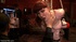 Caged slave plays with a vibrator while another gal serves as human furniture
