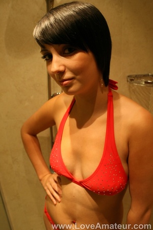 All natural brunette in bikini rubs her tits against the shower door - Picture 1