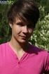 Cute guy wearing pink shirt has fun in the backyard and poses doggy style