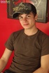Cute boy wearing a cap and sexy red underwear poses in hot positions
