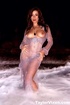 Seductive redhead allures in a beach as she displays her luscious curves