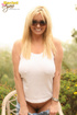 Smiling blonde takes off her jeans and shows her trimmed pussy
