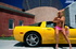Preppy blonde gets super sexy in front of yellow sports vehicle outdoors