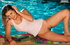 Playful flirt gets wet in pool wearing only a white tank
